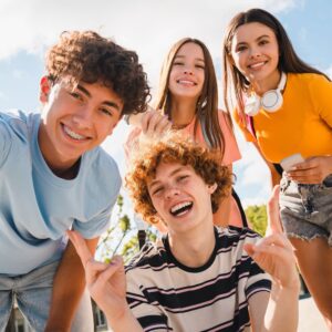 Vier Schulkinder, Teenager, die positive Energie verströmen, sinnbildlich für mentale & positive Stärke im Schulalltag